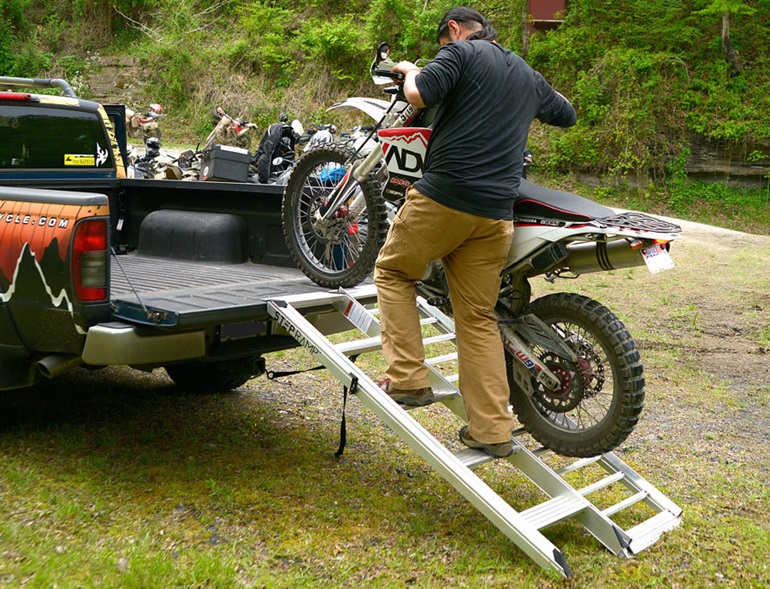 Man climbs dirt bike on ramp