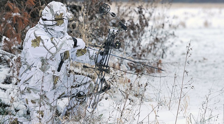 Hunter with camouflaged white clothing for winter