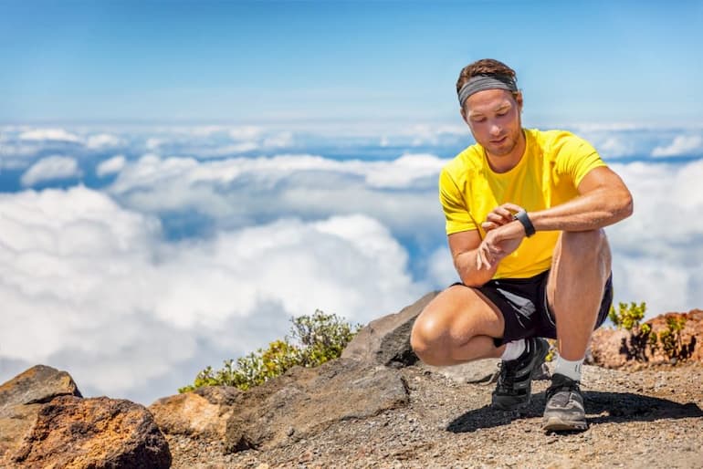 man with GPS hiking watch on mountain