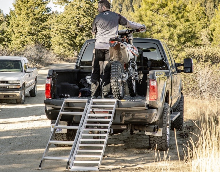 Man with dirt bike in truck with dirt bike ramp